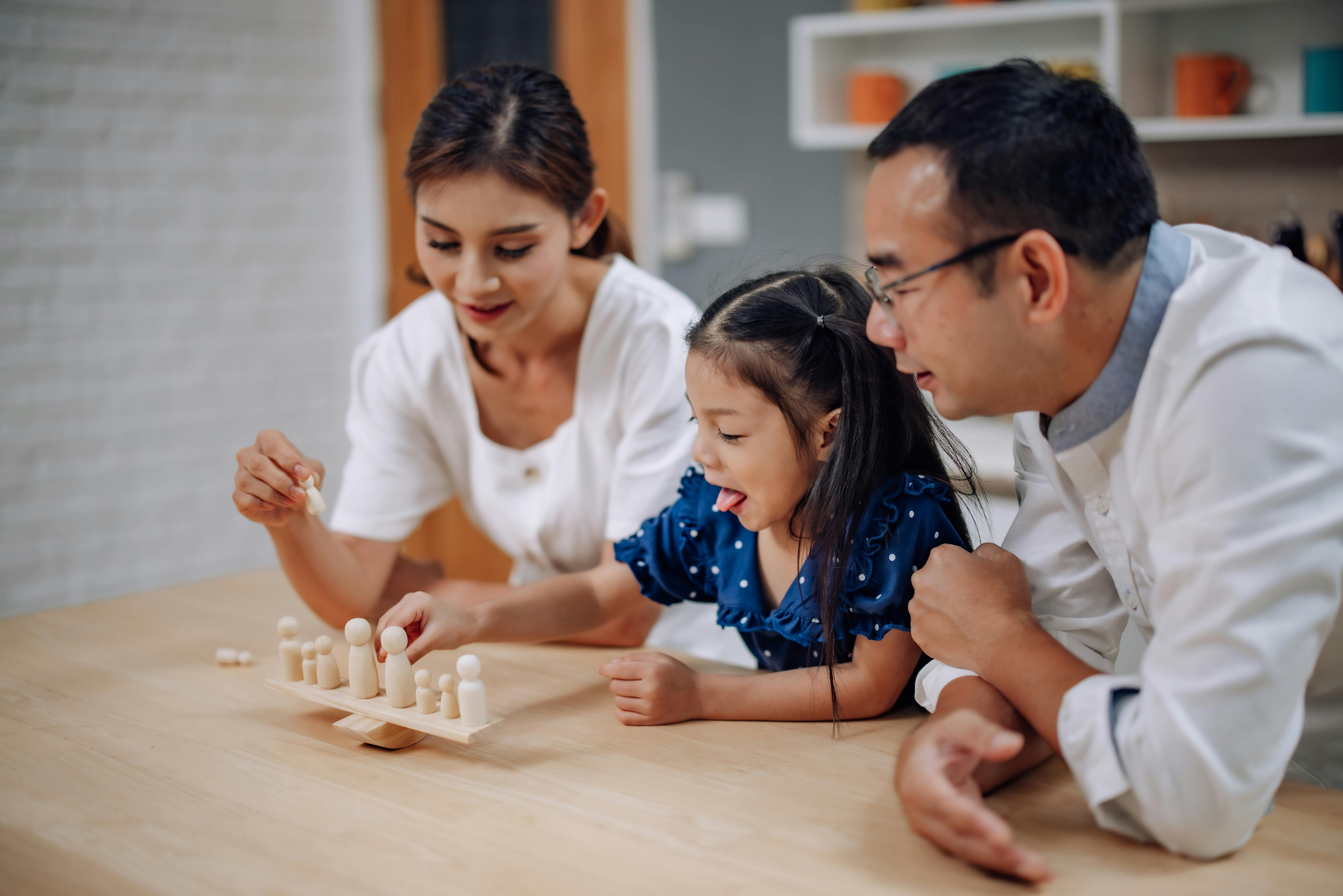 Une famille joue à un jeu de société ensemble à une table.