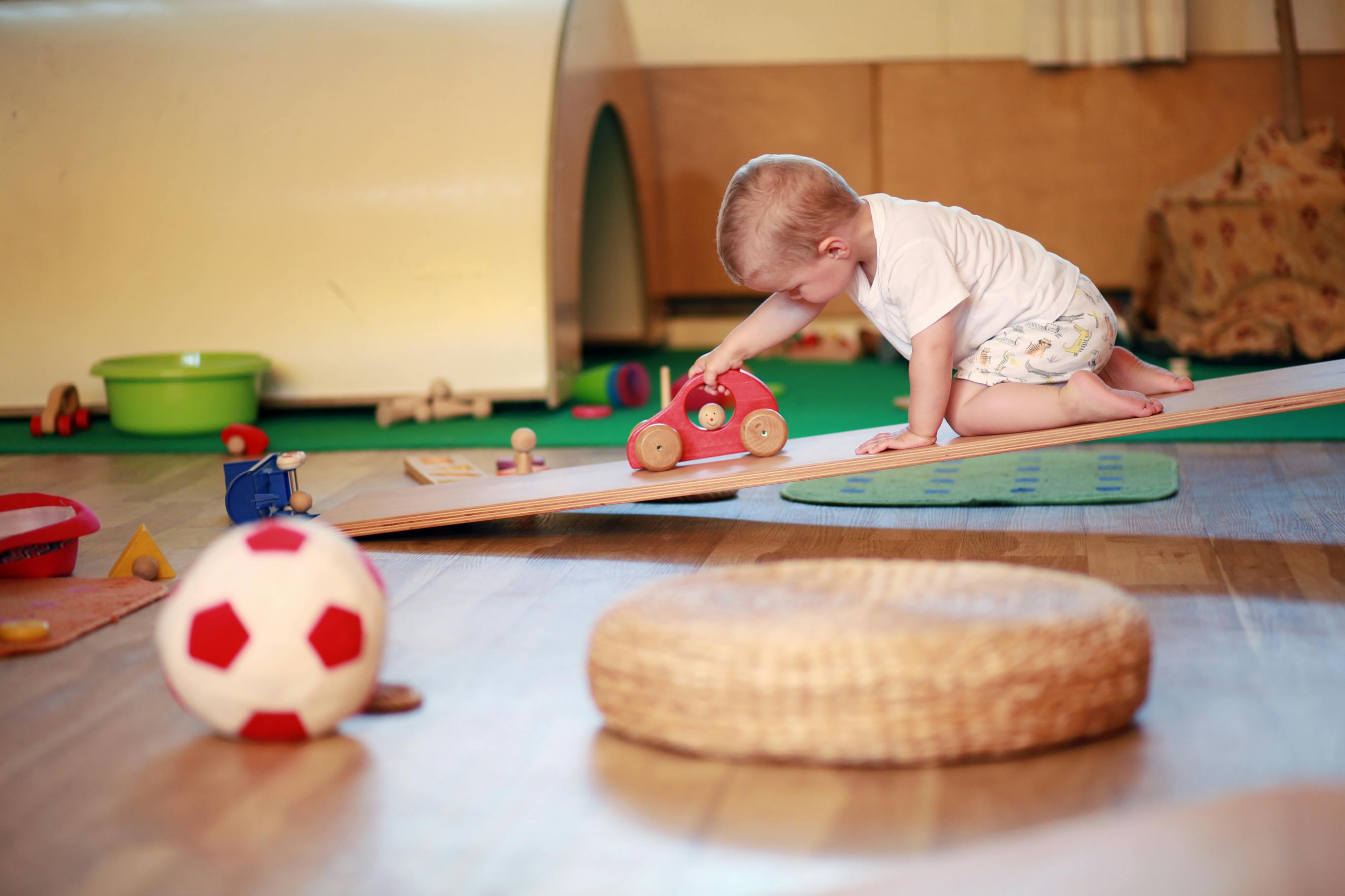 Bébé jouant avec des jouets en bois à l'intérieur.