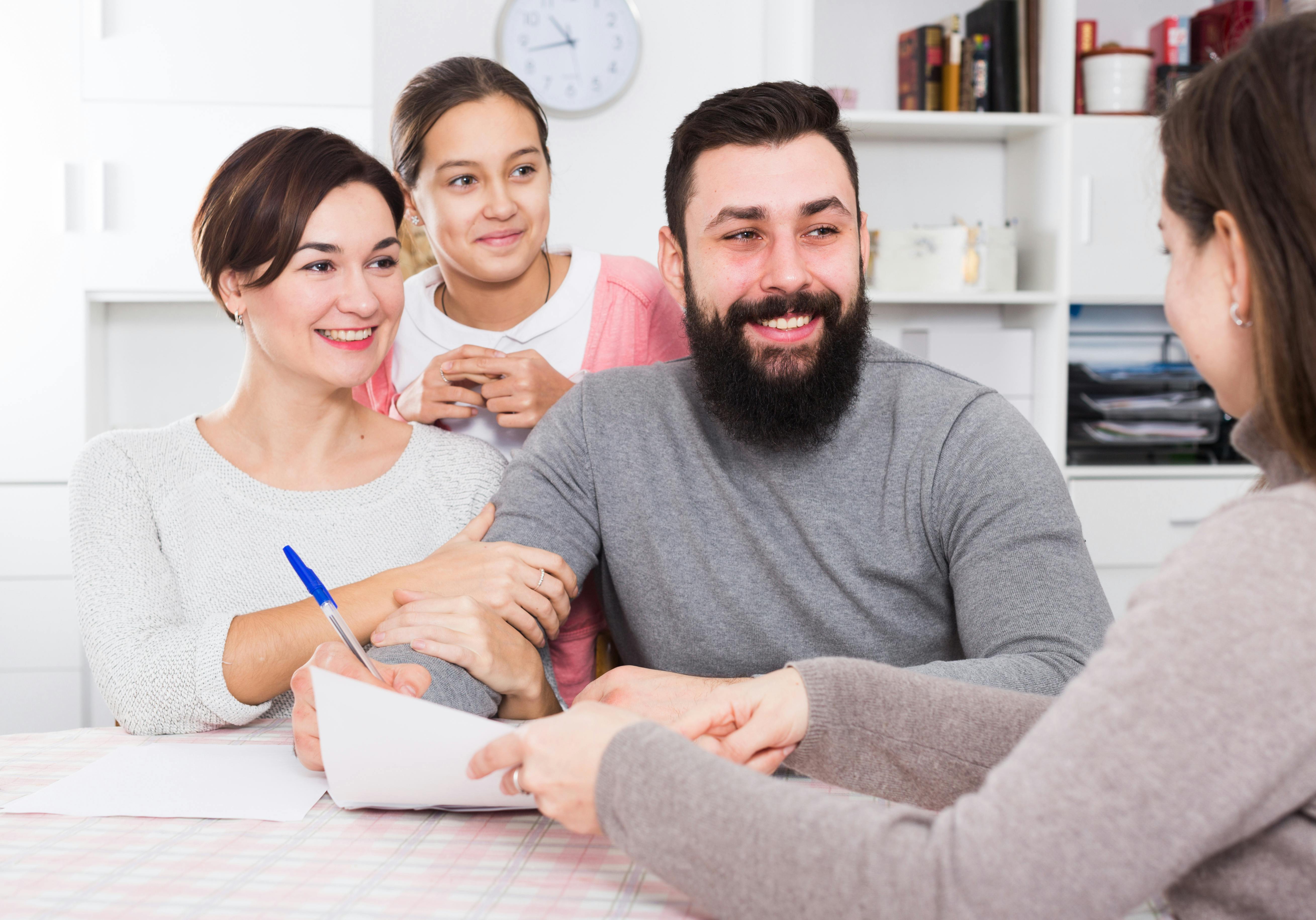 Famille heureuse discutant avec une conseillère autour d'une table.